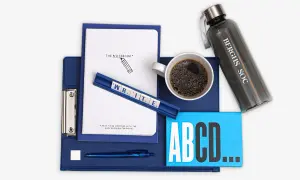 En anteckningsbok, kaffe och bokstäver som bildar "WRITE" förbereder för en argumenterande text.