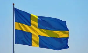 Sveriges flagga vajar i blå himmel. Kanske den viftar för att påminna oss om alla konstiga svenska ord som finns.