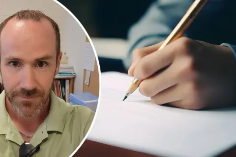 Man med skägg tittar in i kameran. Bredvid syns en hand som skriver med en penna, kanske för att öva på 100 svårstavade ord.
