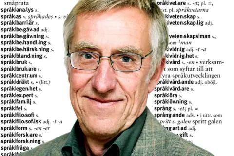 En äldre man med glasögon ler, med text från en ordbok som en bakgrund. Orden "språk" och "blomma ut" kan anas.
