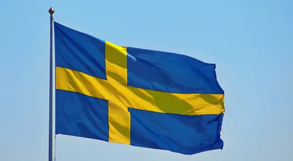 Sveriges flagga vajar i blå himmel. Kanske den viftar för att påminna oss om alla konstiga svenska ord som finns.