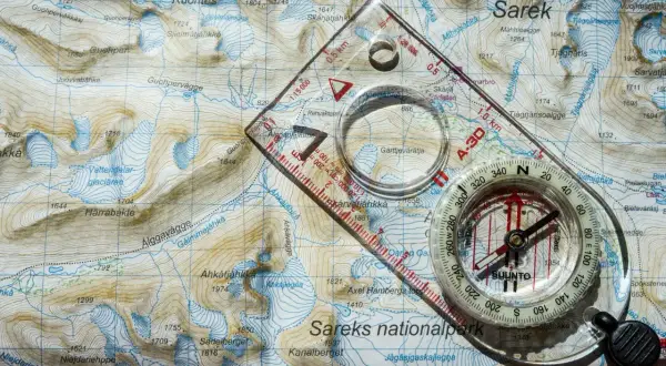 Karta över Sareks nationalpark med kompass och linjal, redo för äventyr i svenskt genus.