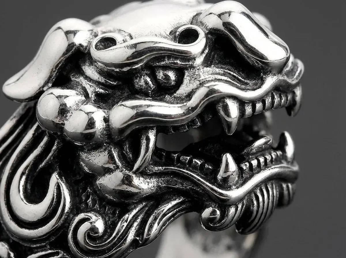 Detaljerad bild av en silverring med ett mytiskt väsen, kanske en drake eller lejon. Vad betyder ringa? Denna ring är ett konstverk.