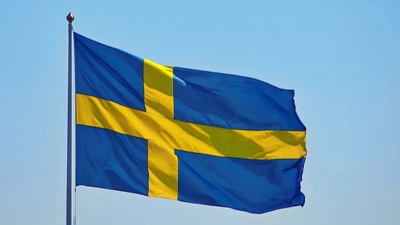 Sveriges flagga vajar i blå himmel. Kanske den viftar för att påminna oss om alla konstiga svenska ord som finns.