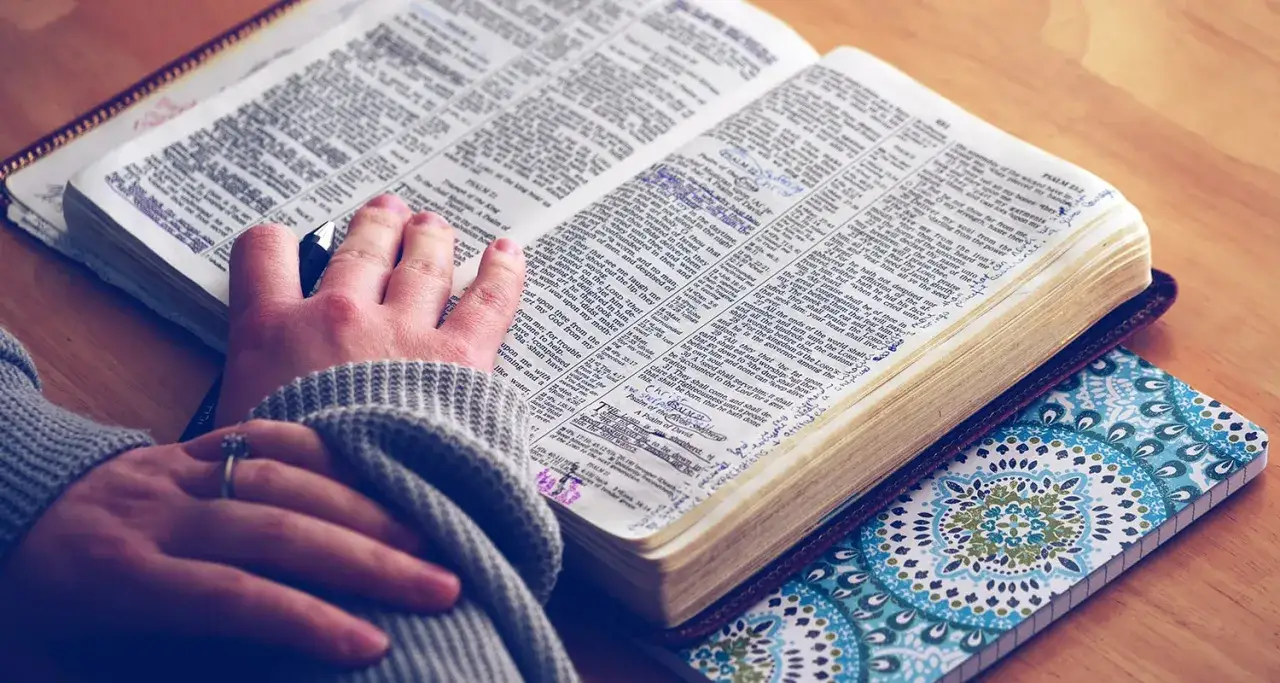 En hand h&aring;ller en penna &ouml;ver en &ouml;ppen bibel, med anteckningar i marginalen. Vad betyder definition?