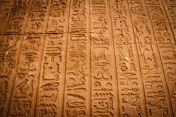Detaljerade hieroglyfer på en stenmur. Varje symbol är mångfacetterad, berättar en historia från forntiden.