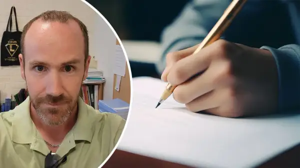 Man med skägg tittar in i kameran. Bredvid syns en hand som skriver med en penna, kanske för att öva på 100 svårstavade ord.