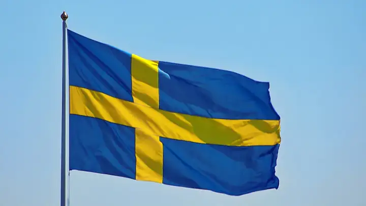 Sveriges flagga vajar i blå himmel. Kanske den viftar för att påminna oss om alla konstiga svenska ord som finns.